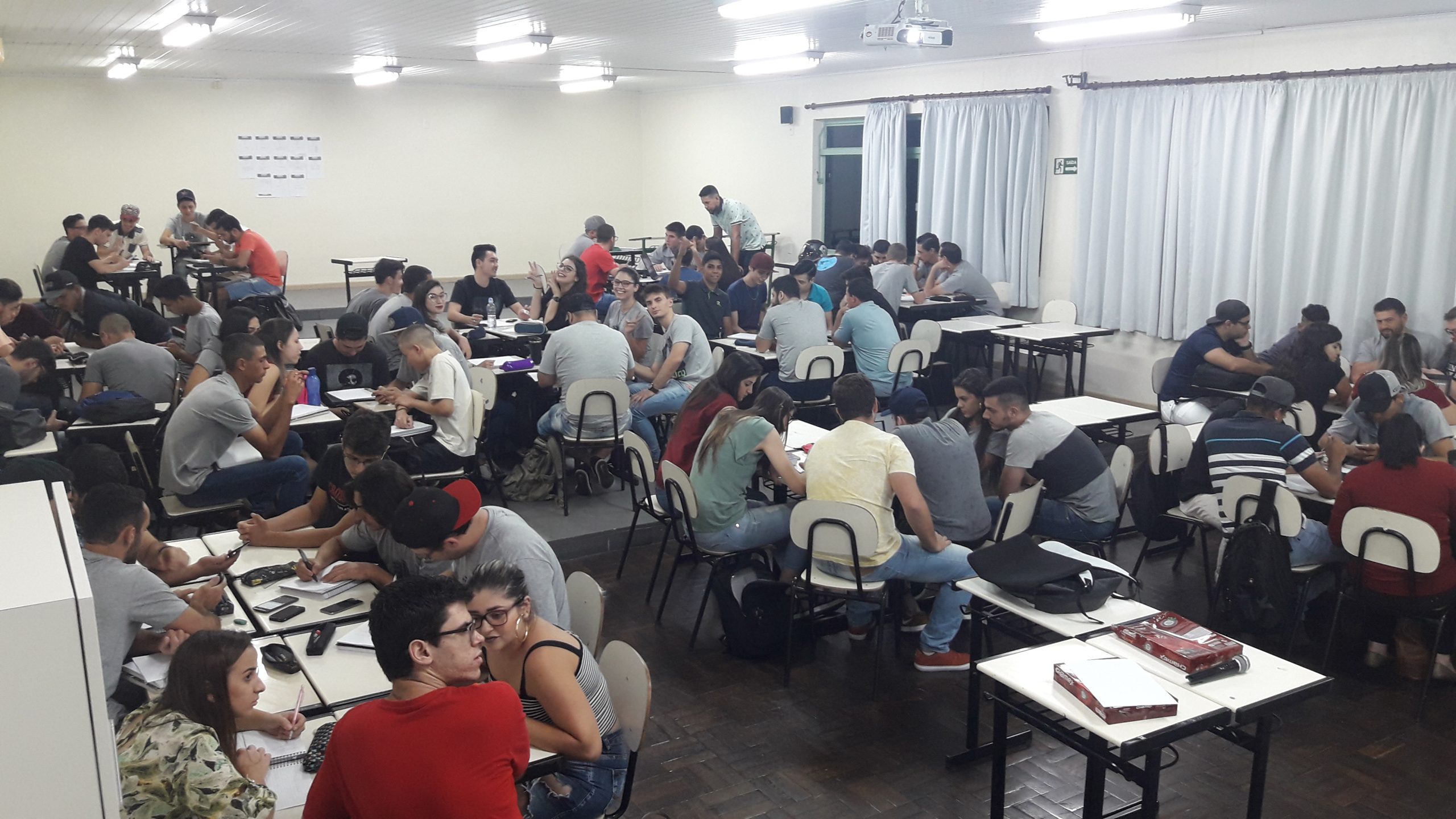 vários grupos de estudantes reunidos em grupos dentro da sala de aula